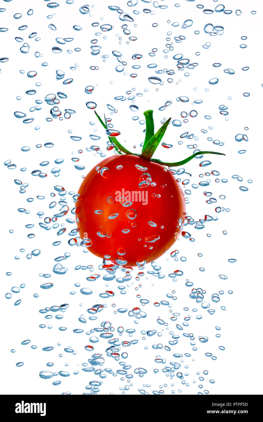 Kleine Kirschtomate Spritzer ins Wasser mit Luftblasen Stockfoto