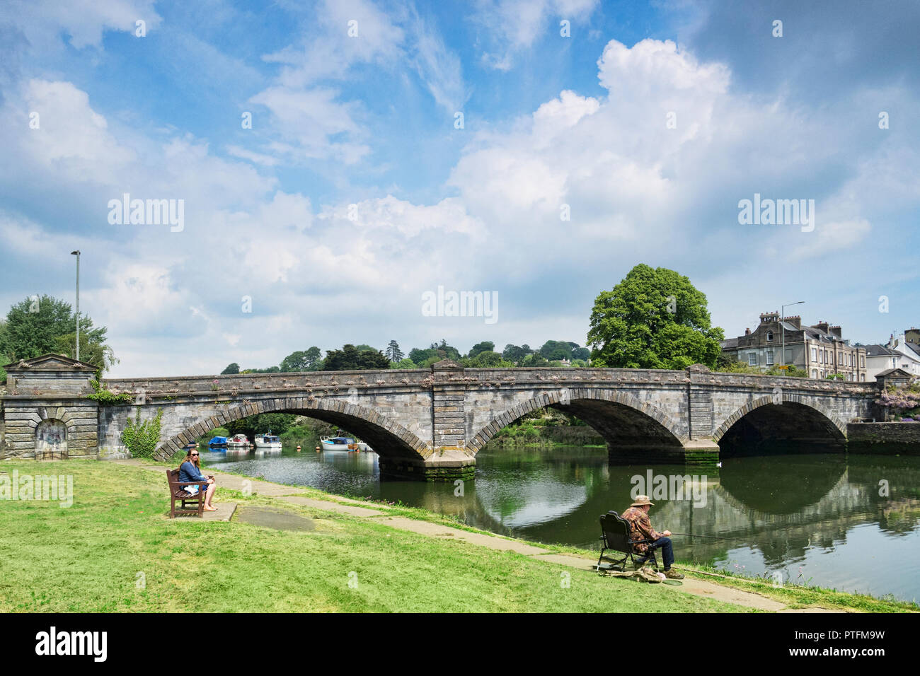 25. Mai 2018: Totnes, Devon, Großbritannien - Totnes Brücke und den Fluss Dart mit einem Mann angeln und schönen Himmel. Die Brücke wurde 1828 gebaut. Stockfoto