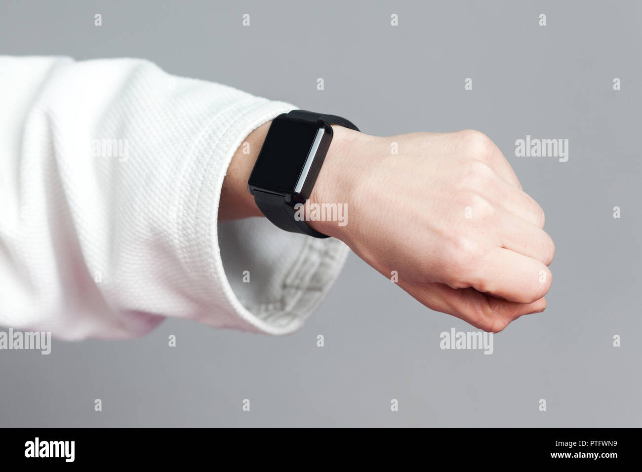 Weibliche Hand in weiße Hülse mit smartwatch zeigen Pulsmesser. helthcare- und Technologiekonzept für den professionellen Sport. Innen- Studio sho Stockfoto
