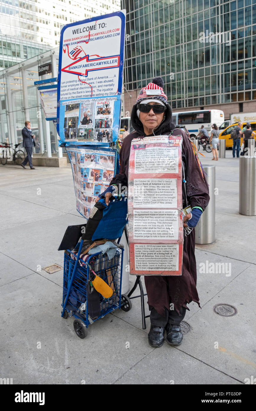 Eine Frau, die an einer Demonstration gegen die Bank von Amerika außerhalb der B eines Gebäudes an der 42nd St. & 6. Avenue in Manhattan, New York City. Stockfoto