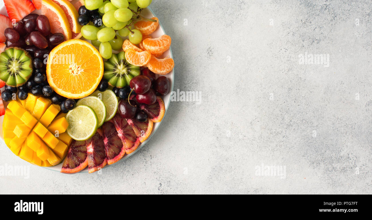 Rohe Früchte Beeren Sortiment platter auf die weiße Platte, Grapefruit Beeren mango Limes orange auf dem Weg weiße Tabelle, Ansicht von oben, kopieren Raum Stockfoto
