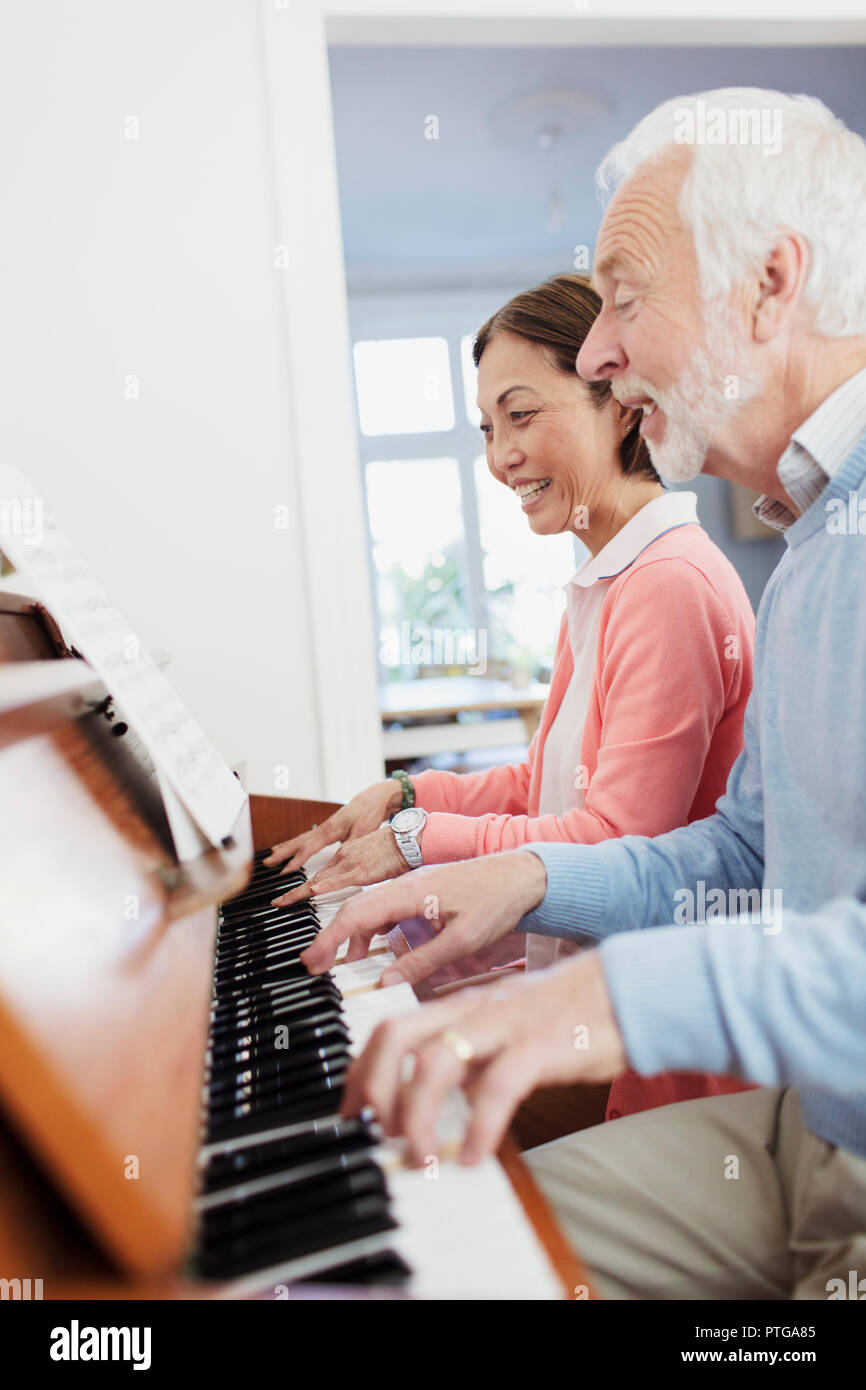 Active Senior paar Klavier spielen Stockfoto