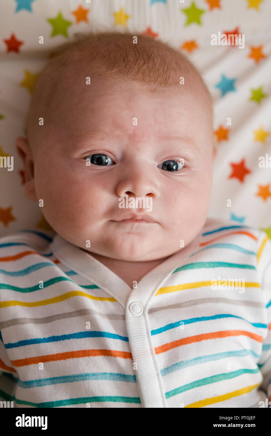 Porträt eines Jungen, der sich auf eine Wickelauflage. Er blickt auf die Kamera mit einem leichten Lächeln. Stockfoto