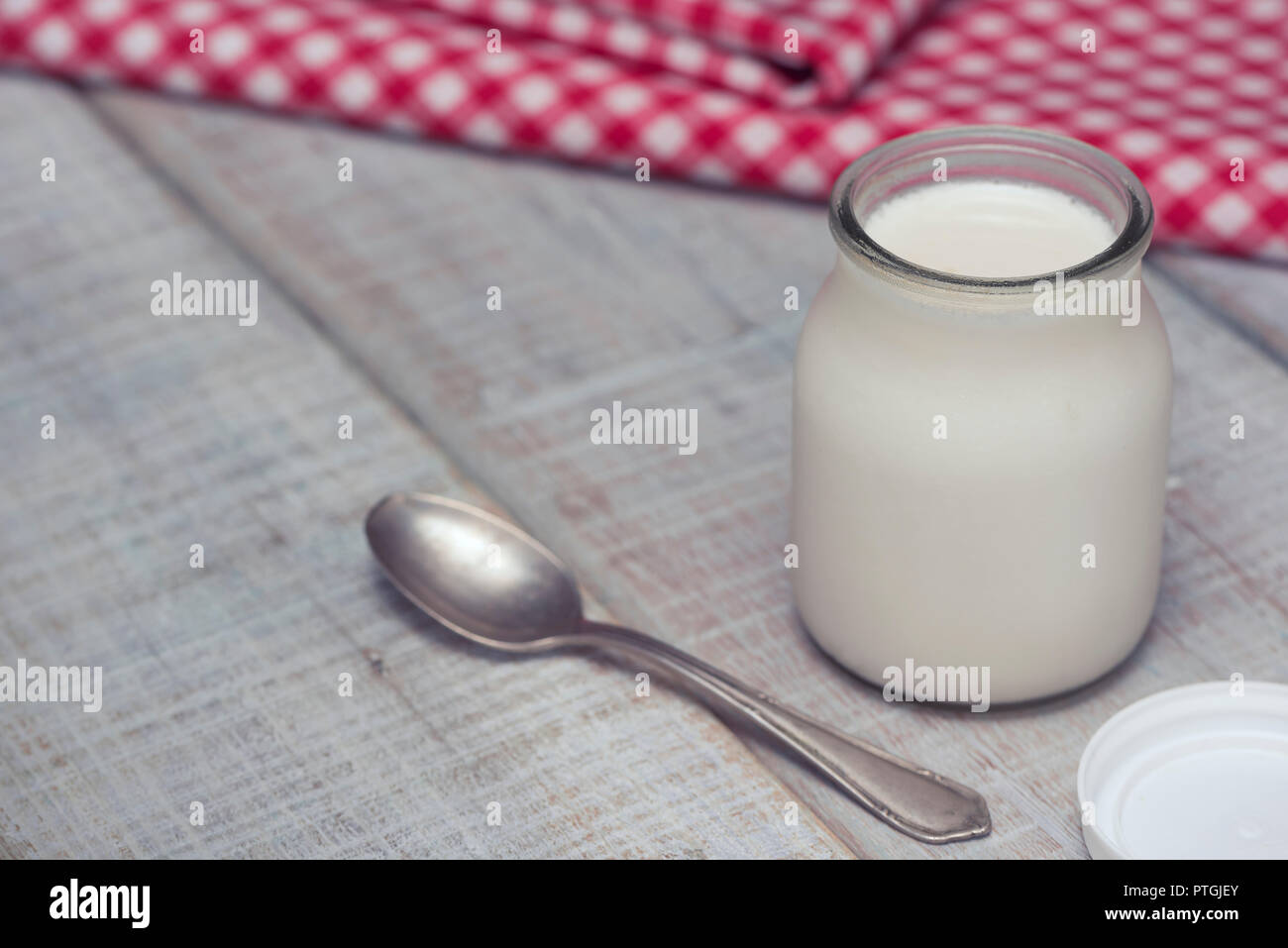 Lecker und gesund weißen hausgemachte Joghurt in Gläsern auf einem weißen Holztisch. Bereit, wie diese zu essen, oder das Hinzufügen von Obst, Getreide oder Nüsse. Stockfoto