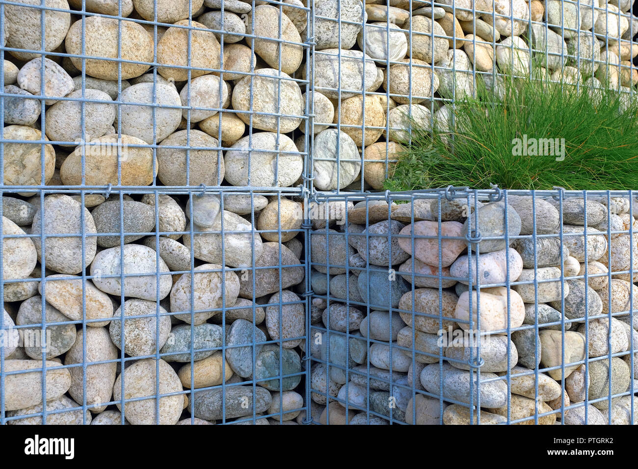 Steinmauern in einem Metallgitter. Das Design der Mall Parkplatz. Stockfoto