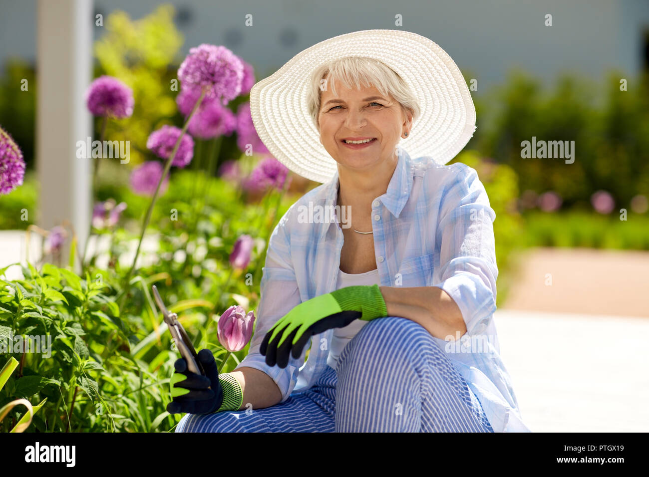 Ältere Frau mit Garten Gartenschere und Blumen Stockfoto