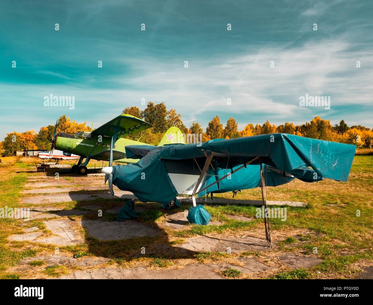 Blick auf klassische Flugzeug auf dem grasbewachsenen Flugplatz; Flugzeuge nach dem Flug mit Fällen auf Propeller und andere Elemente; Freizeit und Unterhaltung Stockfoto