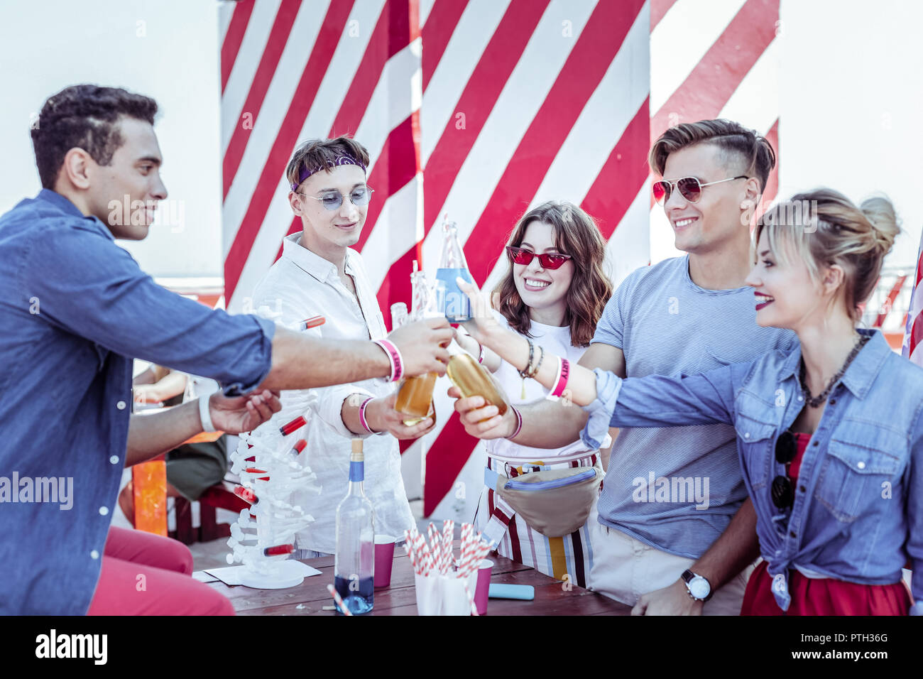 Nahaufnahme der Hände, die berühren Glasflaschen Stockfoto