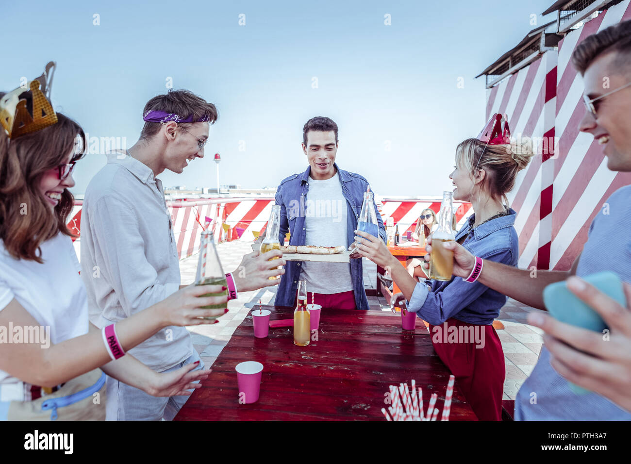 Stattliche brünette Mann hält Papier Box mit Pizza Stockfoto