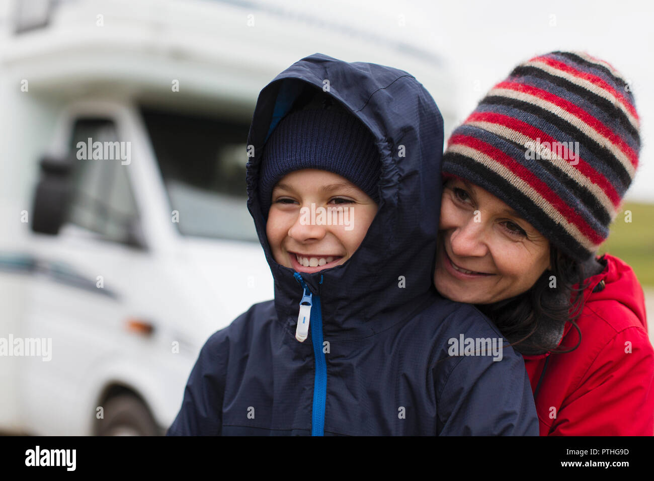 Liebevolle Mutter und Sohn in warme Kleidung umarmen außerhalb Motor home Stockfoto