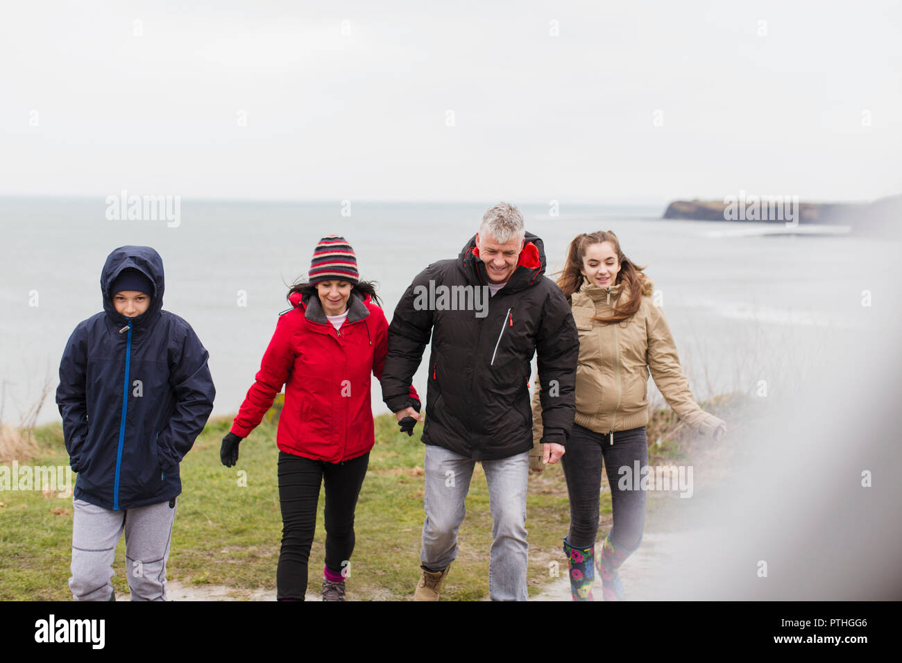 Familie in warme Kleidung auf einer Klippe mit Blick auf den Ozean Stockfoto