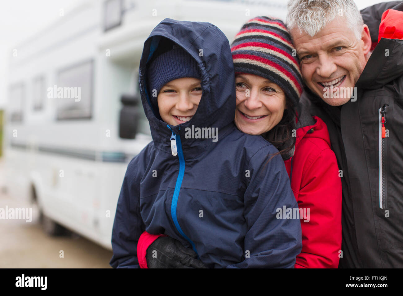 Portrait liebevolle Familie in warme Kleidung umarmen außerhalb von Motor home Stockfoto