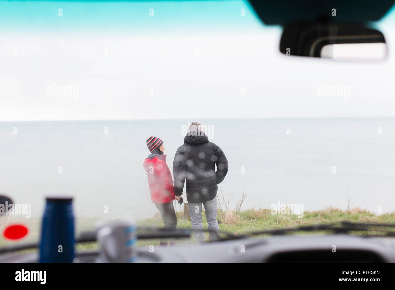 Paar außerhalb der Motor home auf einer Klippe mit Blick auf den Ozean Stockfoto