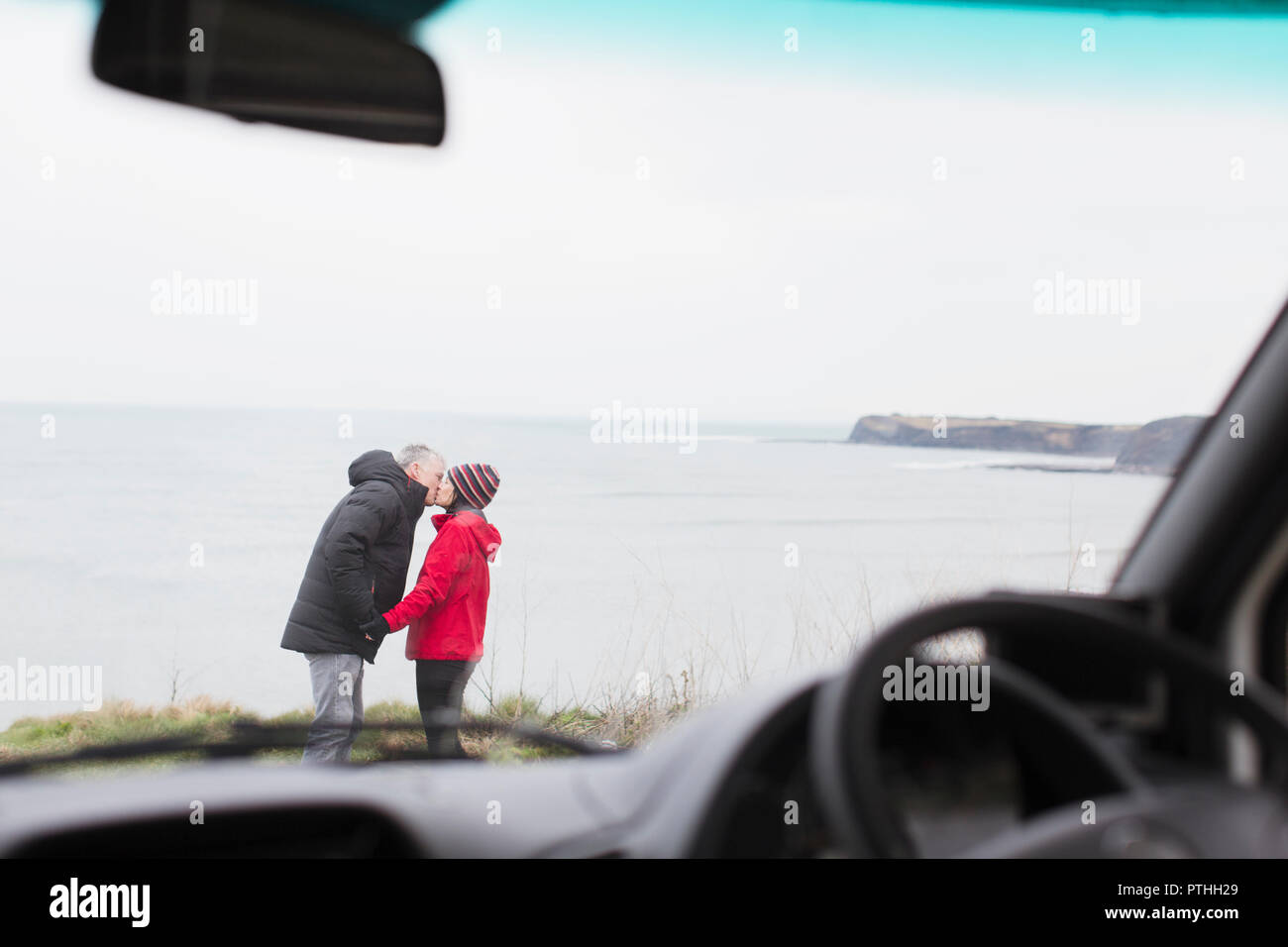 Zärtlich paar Küssen außerhalb Motor home auf einer Klippe mit Blick auf den Ozean Stockfoto