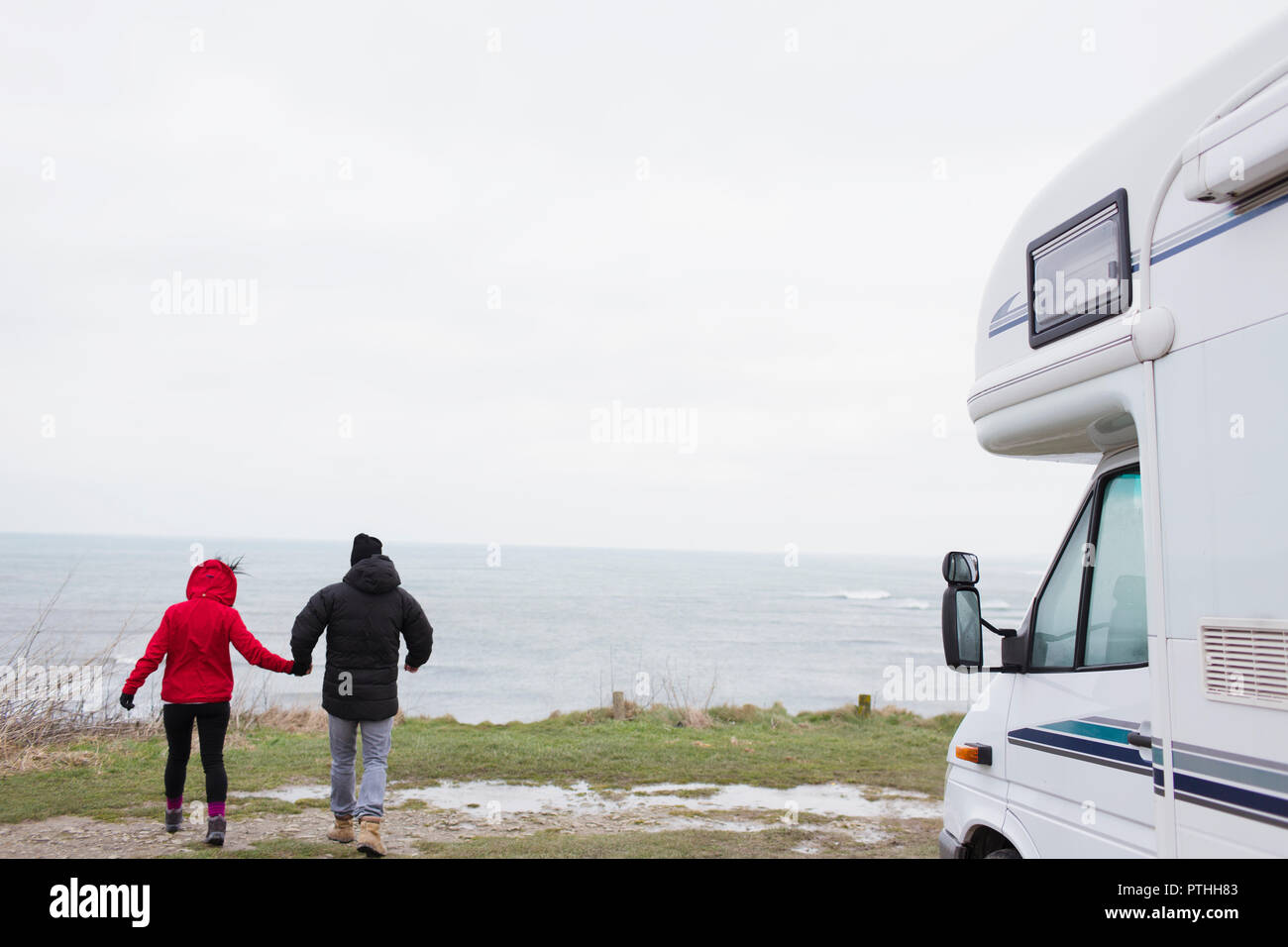 Paar Hände halten außerhalb Motor home mit Blick auf den Ozean Stockfoto