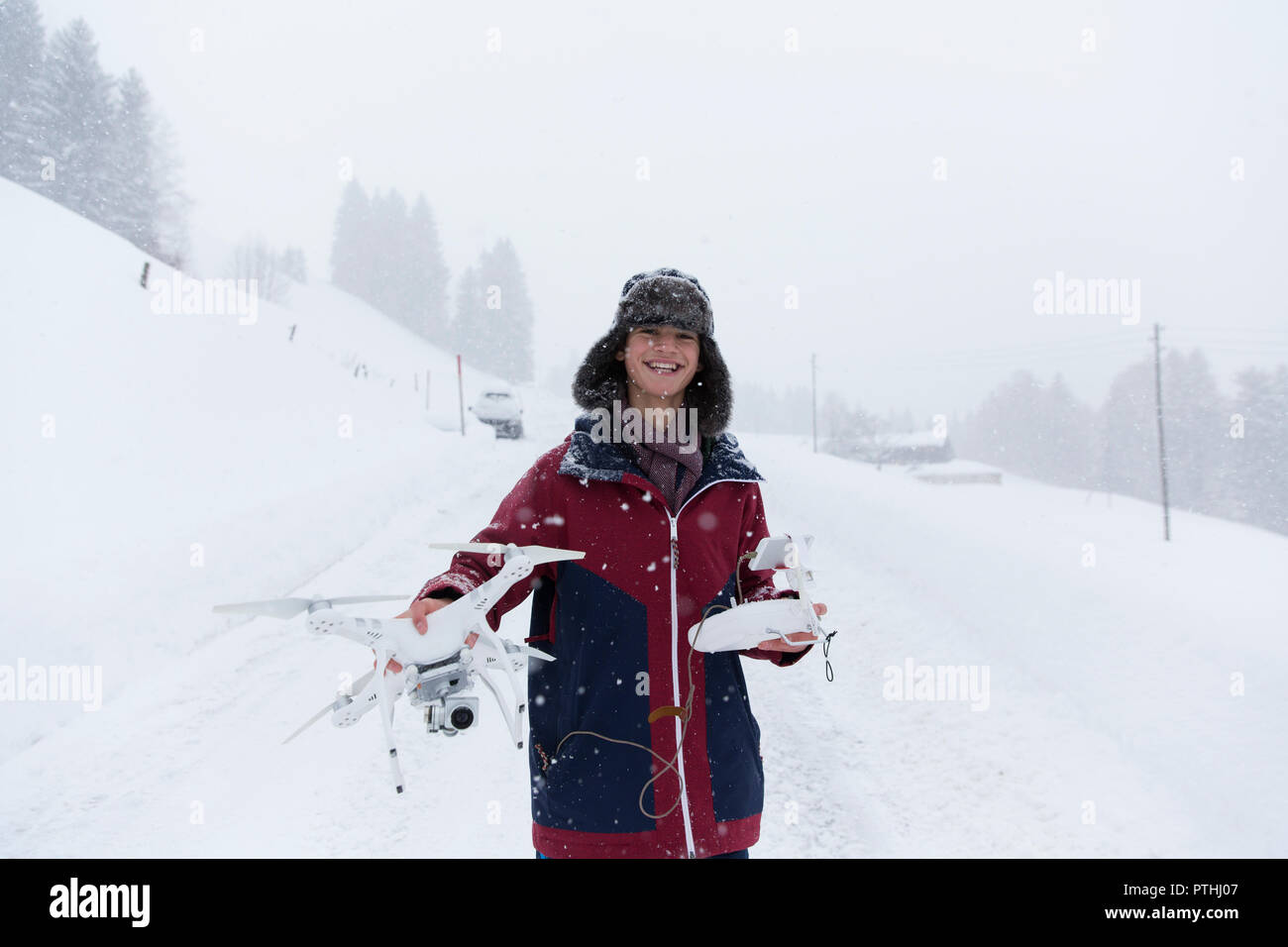 Portrait lächelnden Teenager mit Drone in verschneiter Landschaft Stockfoto