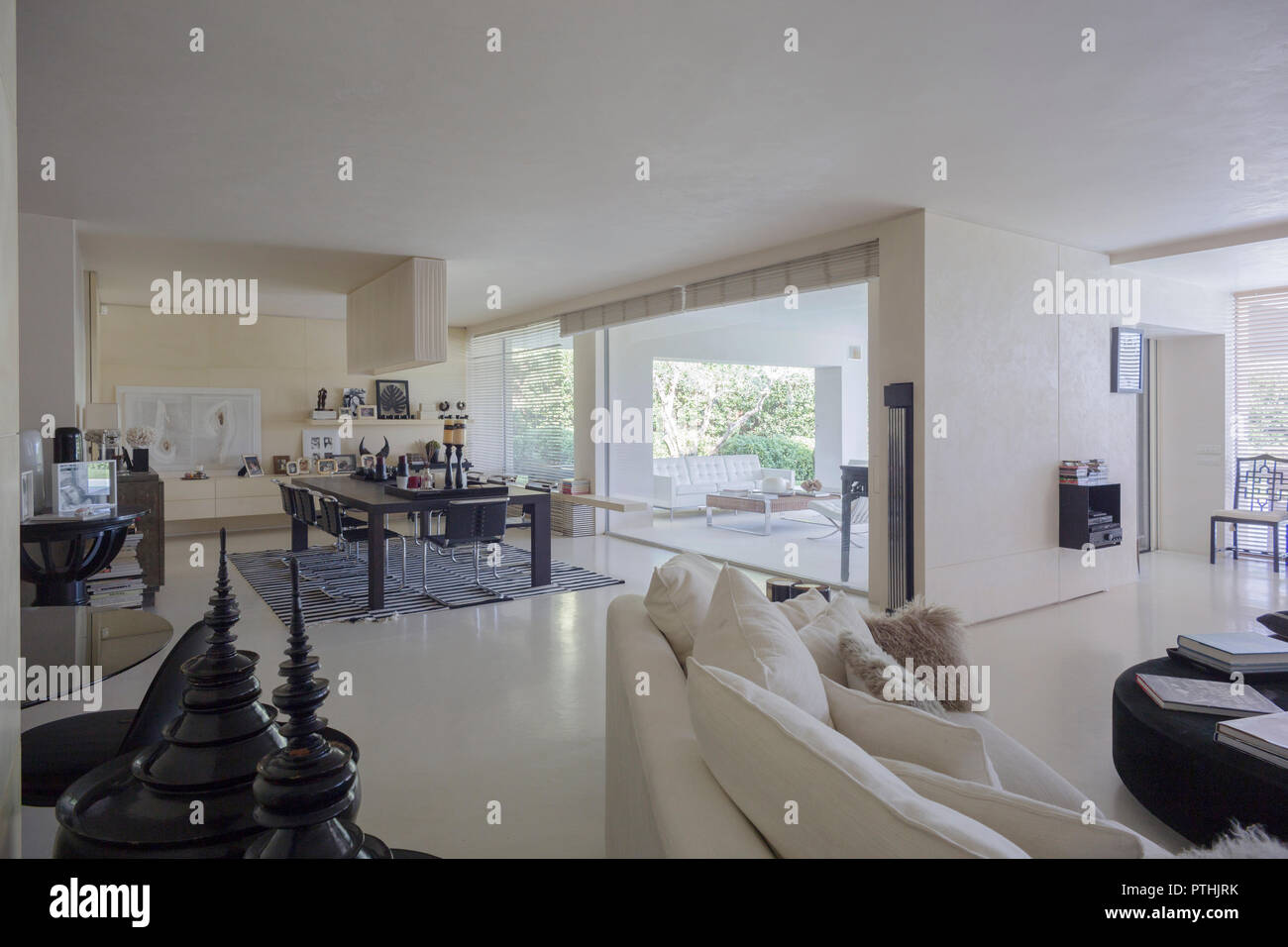 Interieur mit einem eleganten Wohnzimmer mit Blick auf einen privaten Garten in einem Haus in Italien Stockfoto