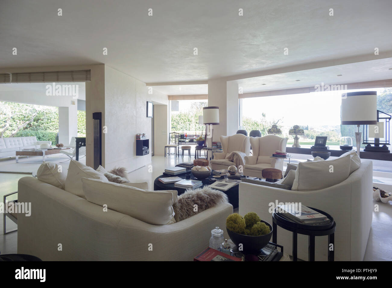 Interieur mit einem eleganten Wohnzimmer mit Blick auf einen privaten Garten in einem Haus in Italien Stockfoto