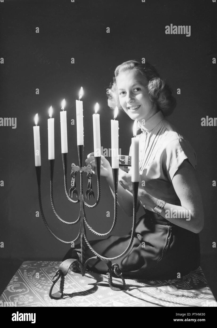 Weihnachten in den 1940er Jahren. Margit Sjödin ist die Beleuchtung der Kerzen zu Weihnachten. Schweden 1940 Stockfoto