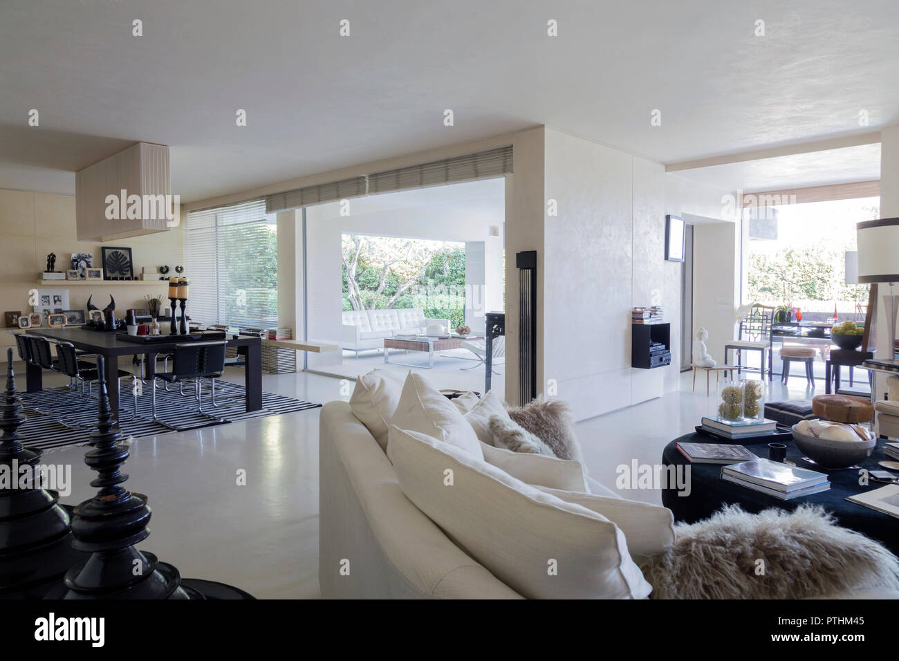 Interieur mit einem eleganten Wohnzimmer mit Blick auf einen privaten Garten in einem Haus in Italien Stockfoto