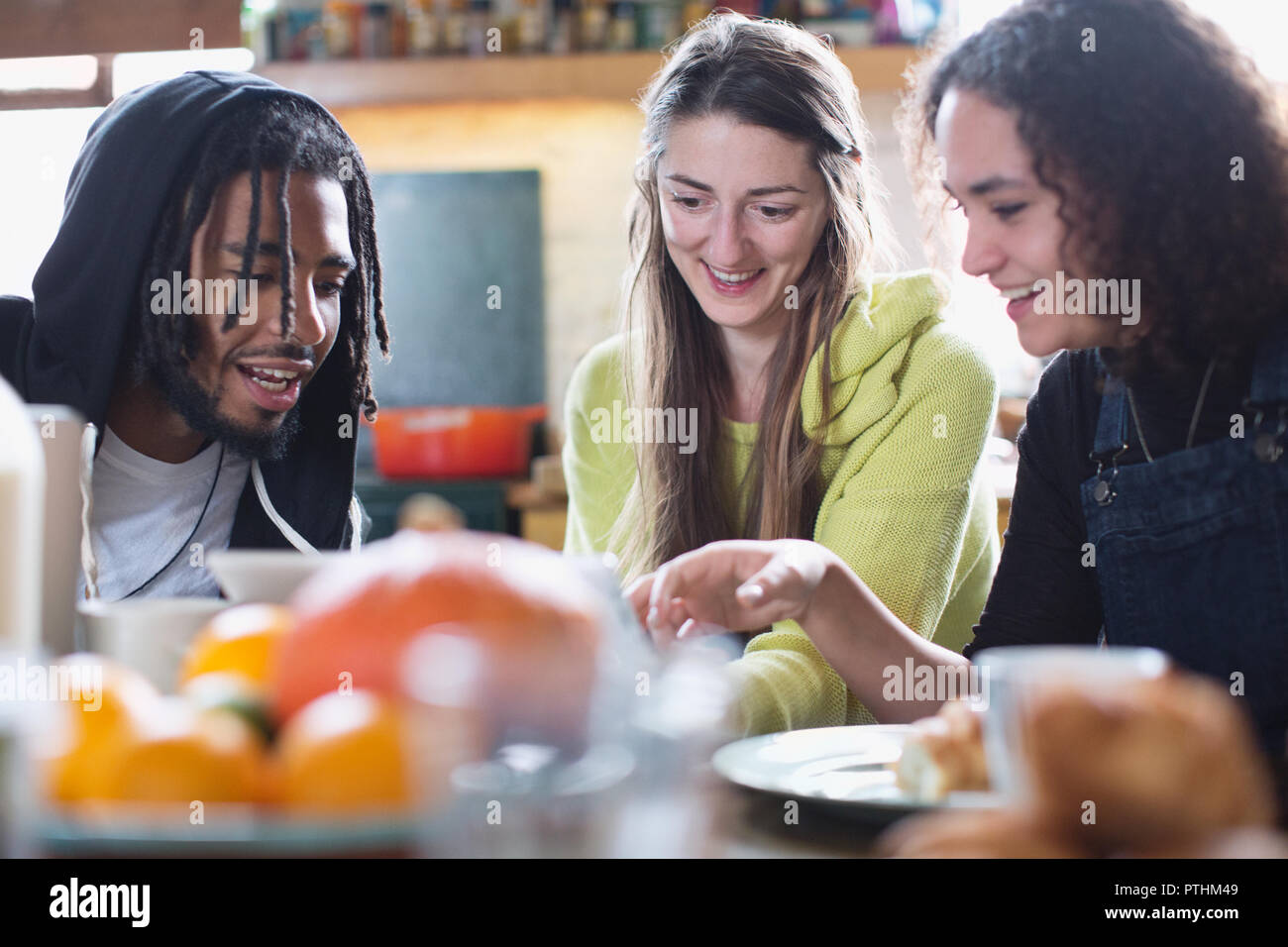 Jungen Mitbewohner Freunde mit digitalen Tablet am Frühstückstisch Stockfoto