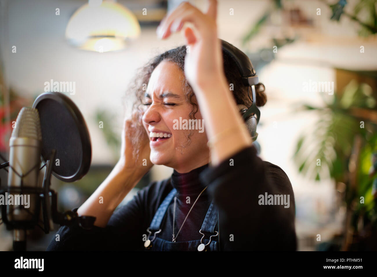 Junge Frau Aufnehmen von Musik, singen Sie in das Mikrofon Stockfoto