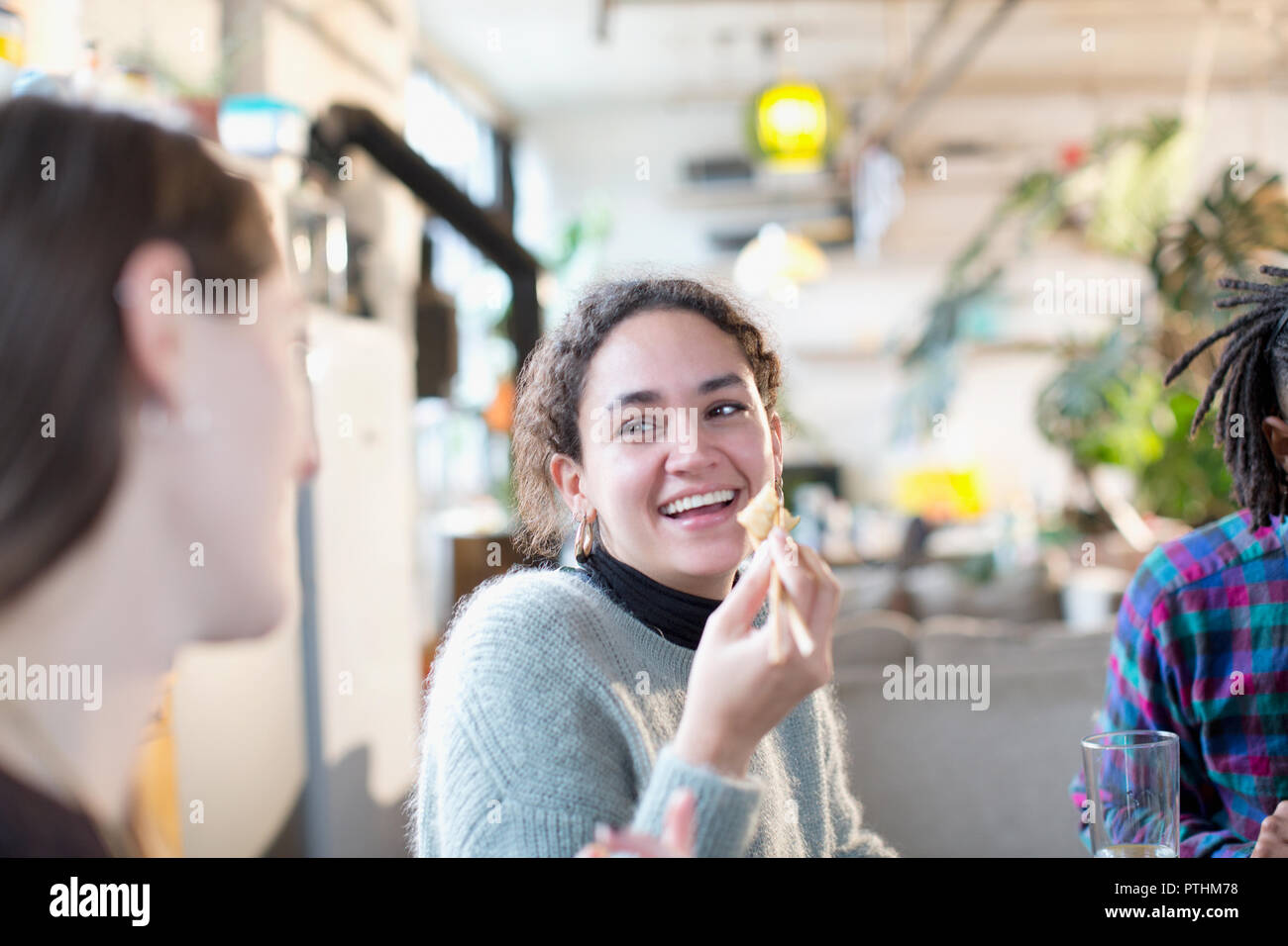 Lachende junge Frau genießen chinesische Takeout Essen mit Freunden Stockfoto