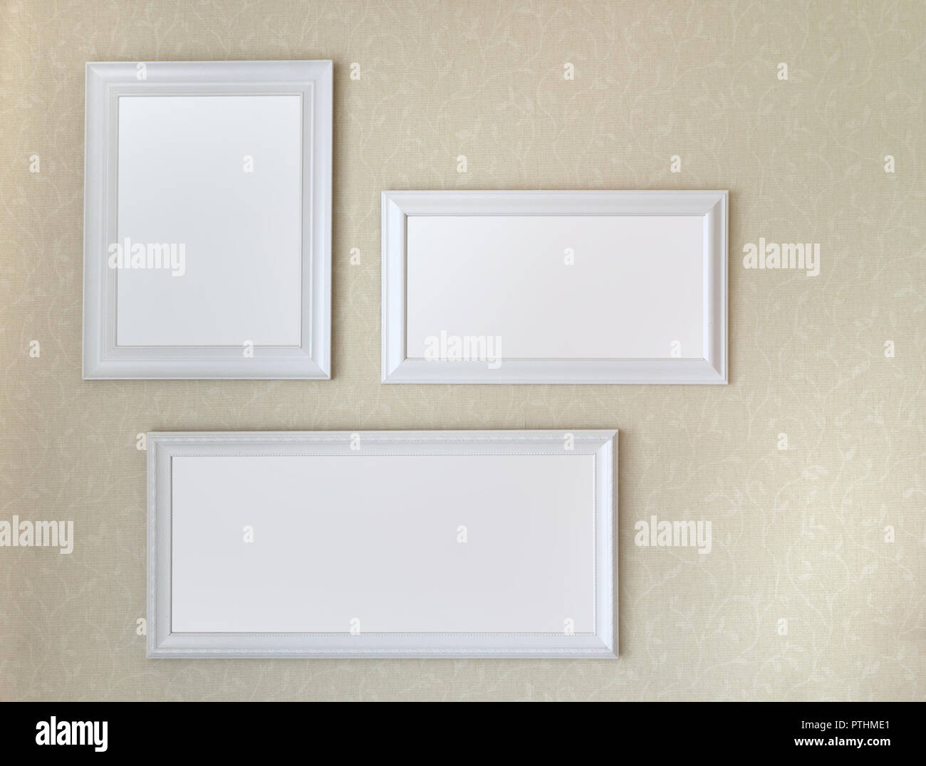 Drei weiße Holzrahmen hängen auf weiche gelbe Wand mock up Vorlage. Stockfoto