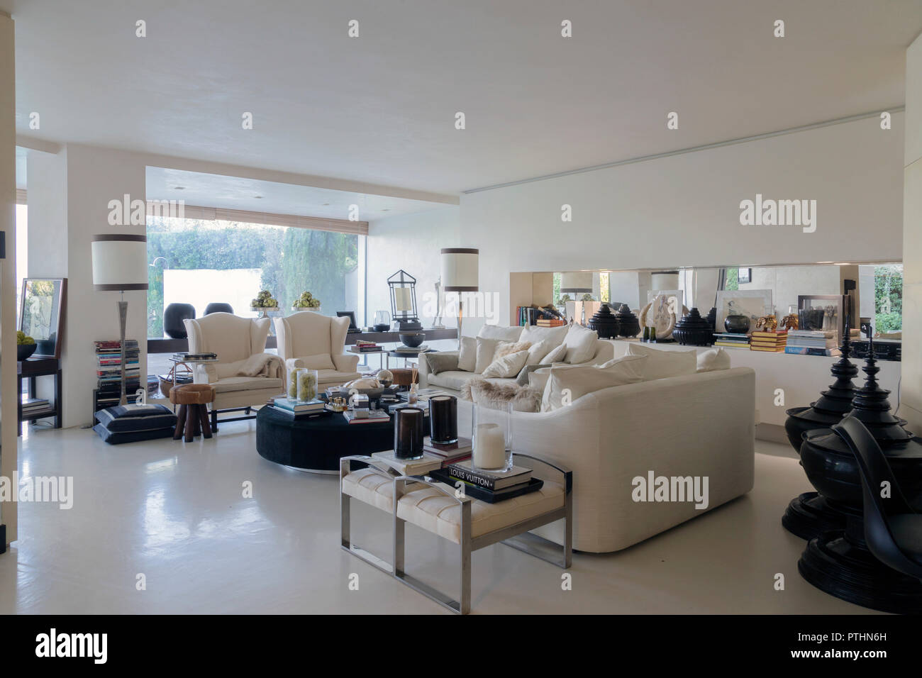 Interieur mit einem eleganten Wohnzimmer mit Blick auf einen privaten Garten in einem Haus in Italien Stockfoto