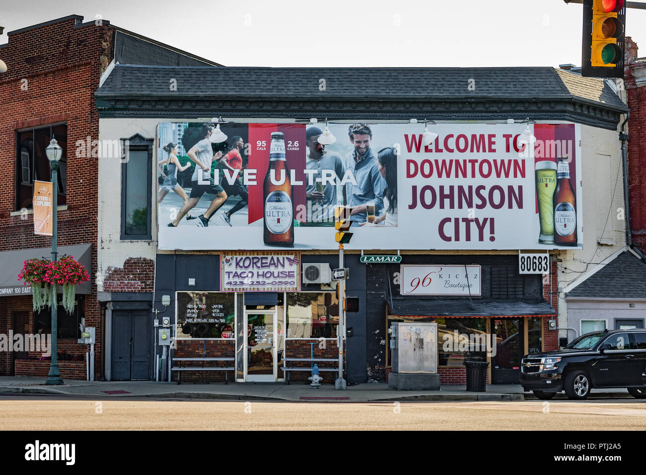 JOHNSON CITY, TN, USA -9/30/18: ein willkommenes Zeichen von Michelob gefördert wird deutlich sichtbar in einem Quadrat in der Innenstadt gebucht, mit zwei kleinen Unternehmen weiter unten. Stockfoto