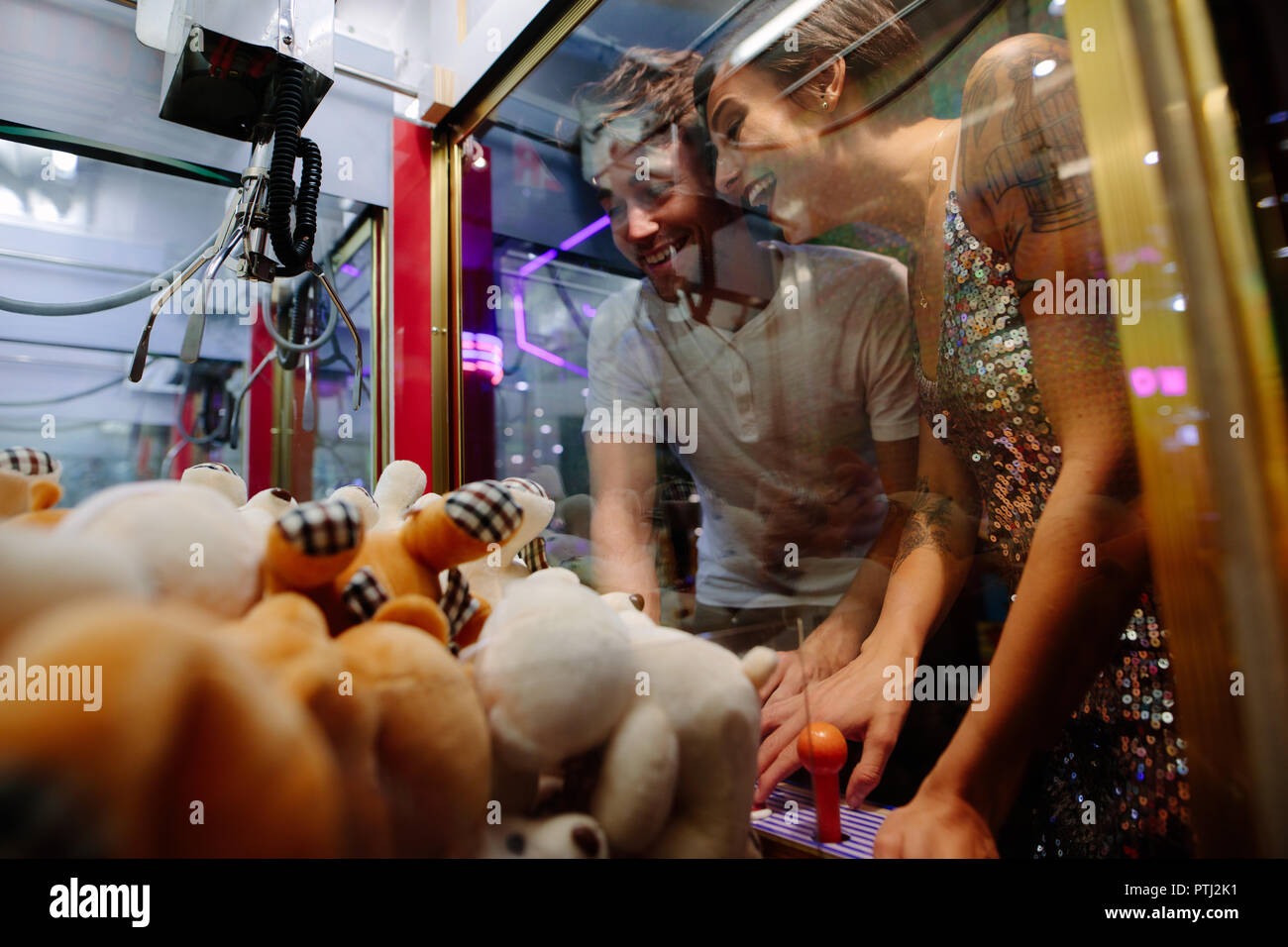 Glückliches Paar spielen Spiele Spiele Arcade. Mann und Frau Spaß an einem Gaming Salon spielen Münzen spielen. Stockfoto