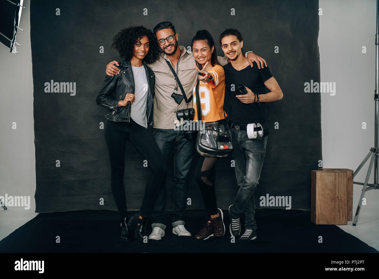 Happy Shooting Team gemeinsam in einem Studio. Fotograf mit dem Modell und Make-up-Künstler während ein Foto schießen. Stockfoto