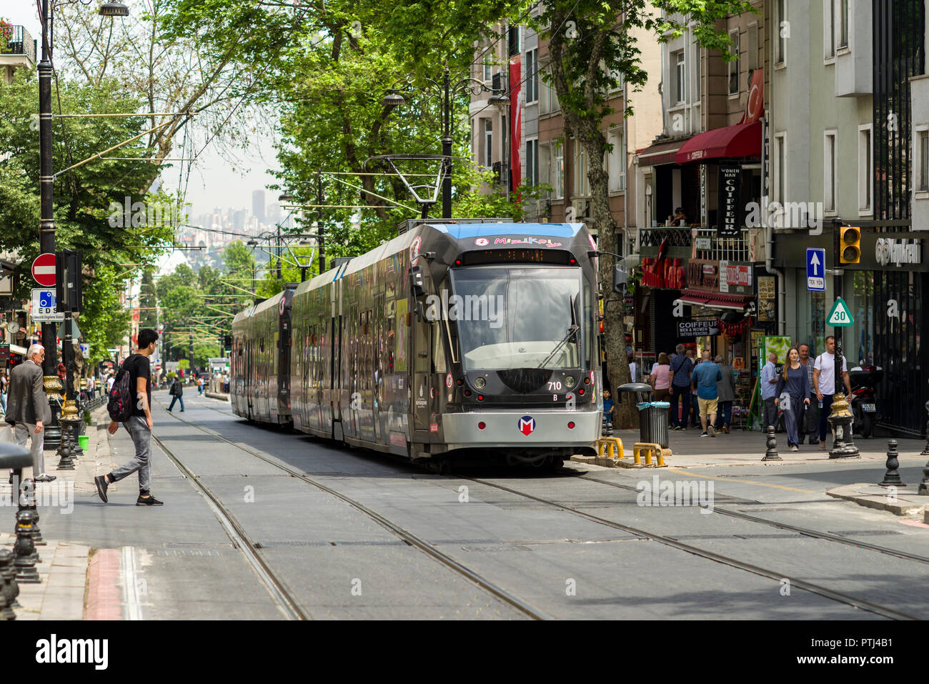 Ein T1-Kabatas-Bagcilar elektrische U-Straßenbahn fährt nach unten ein Boulevard Vergangenheit Gebäude und Menschen im Stadtteil Fatih the Golden Horn, Istanbul, Turke Stockfoto