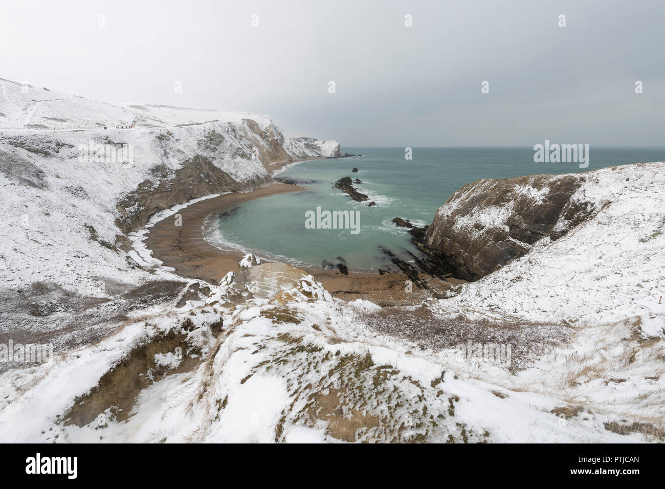 Mann-O Krieg Cove im Schnee an der Küste von Dorset. Stockfoto