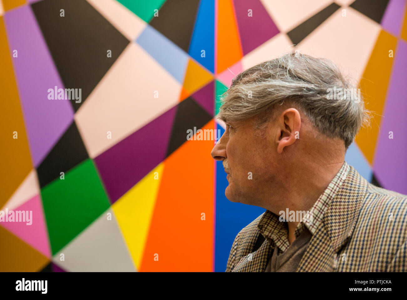 Der Mensch auf der Suche nach Bunten geometrischen Kunstwerke in der Galerie für Moderne Kunst in Leeds. Stockfoto