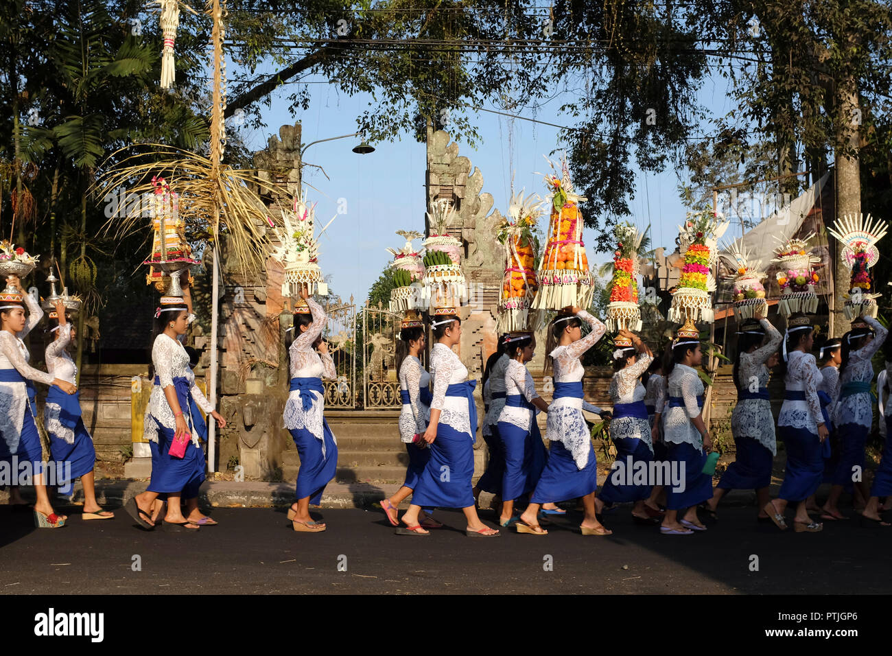 Balinesische Frauen in traditioneller Kleidung während einer religiösen Prozession auf der Straße. Stockfoto