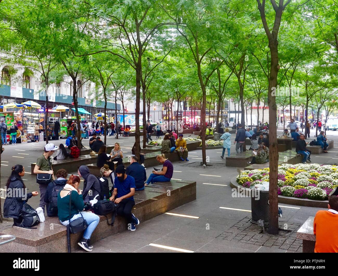 Menschen sitzen, arbeiten, entspannen im Zuccotti Park am Broadway, Lower Manhattan, in New York City, NY, USA. Stockfoto