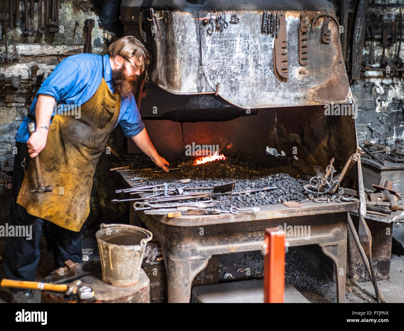 Schmied bei der Arbeit. Arbeiten von Blacksmith im Welsh National Slate Museum in Llanberis North Wales Stockfoto