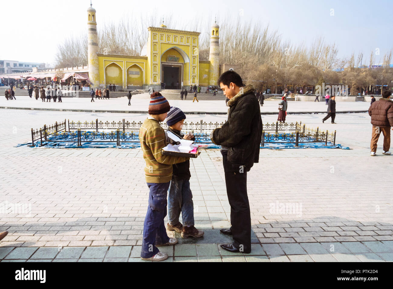 Kashgar, Xinjiang, China: Zwei uigurischen Kinder Süßigkeiten verkaufen gegenüber der gelben Fliesen- Id kah-Moschee (1442), die geistige und physische Herz der Cit Stockfoto