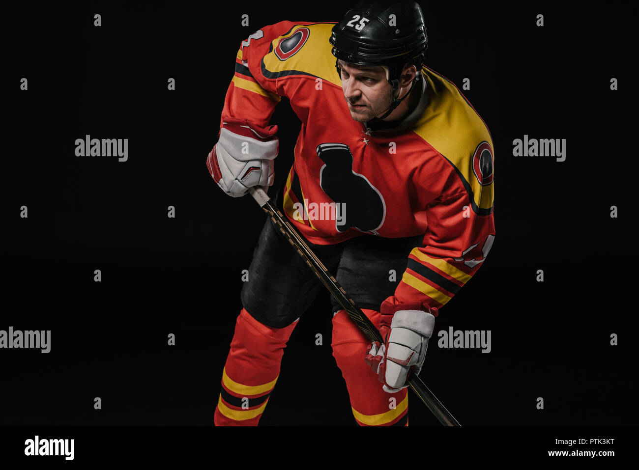 Professional Hockey Spieler in sportschutzausrüstungen Holding hockey stick und Wegsehen auf Schwarz isoliert Stockfoto