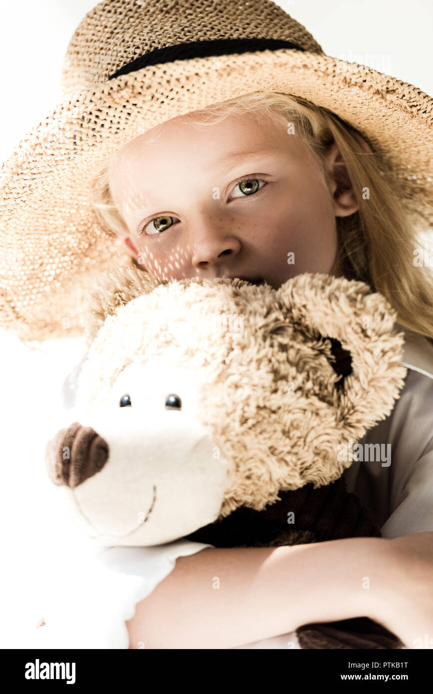 Adorable Kind in wicker hat Holding Teddybär und Kamera auf Weiß Stockfoto