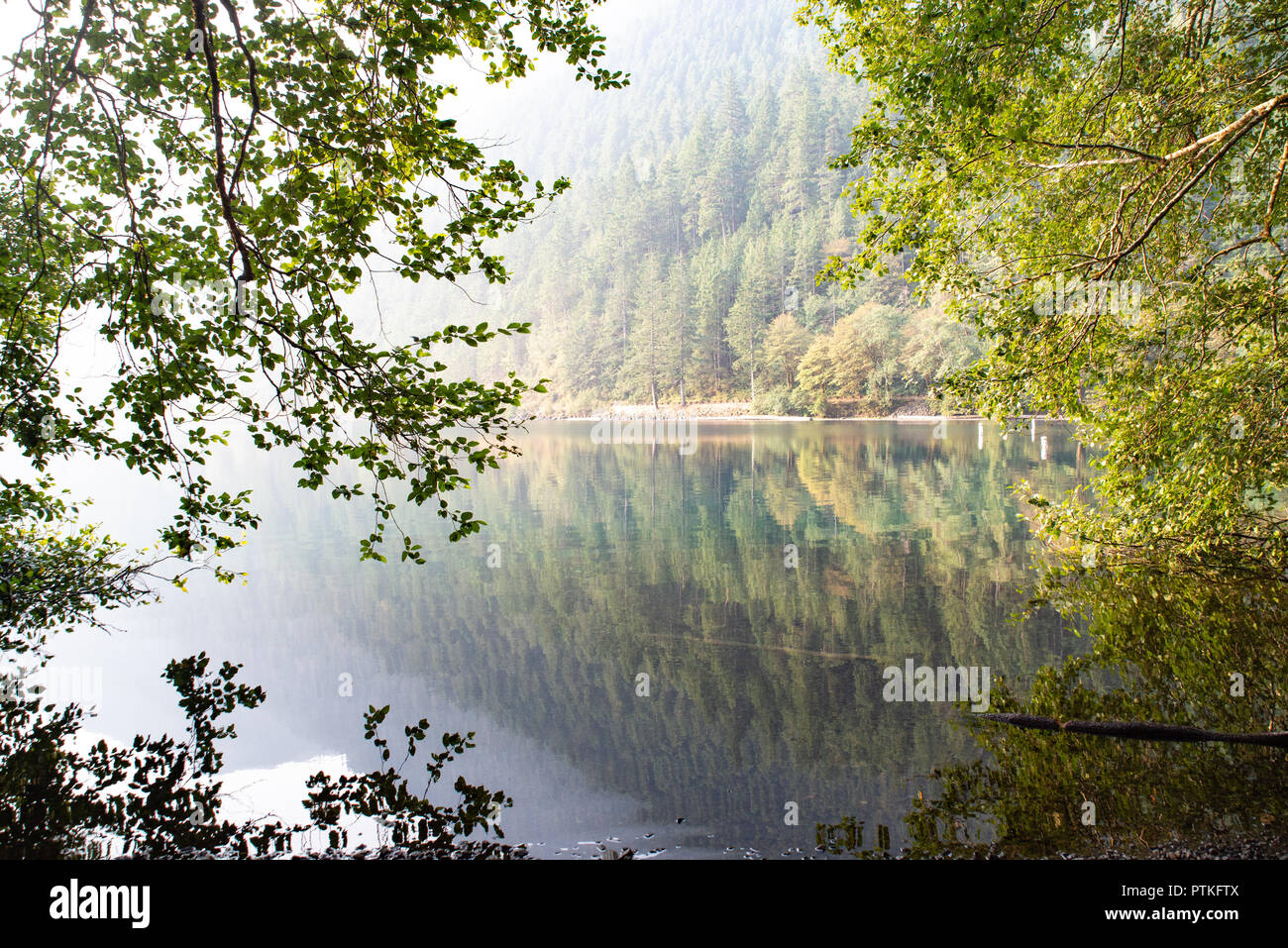 Am frühen Morgen bei Sonnenaufgang, die Ruhe des Sees und Campingplatz beim Camping genießen. Reflexionen über den See auf die Berge. Stockfoto