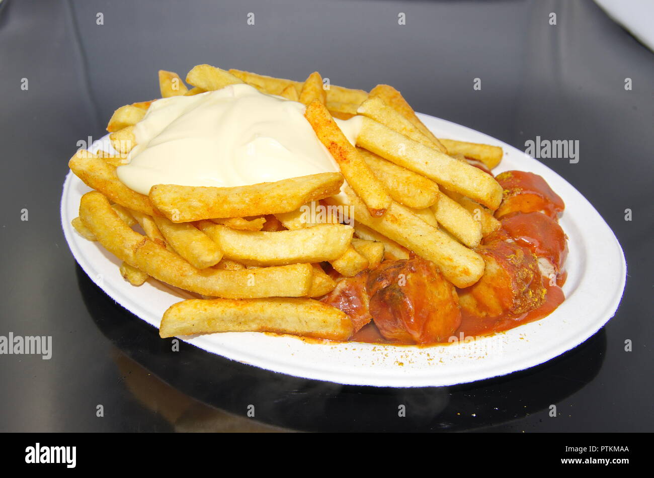 Currywurst mit Pommes Mayo mit weißem Teller im Ruhrpott Stockfoto