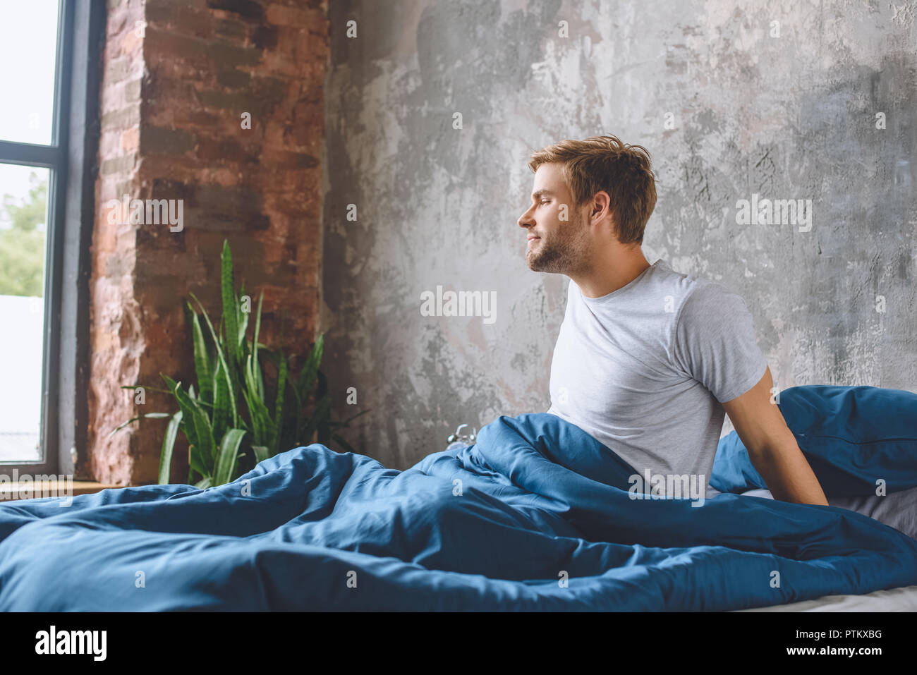 Hübscher junger Mann wach in seinem Bett während der Morgen Zeit zu Hause Stockfoto