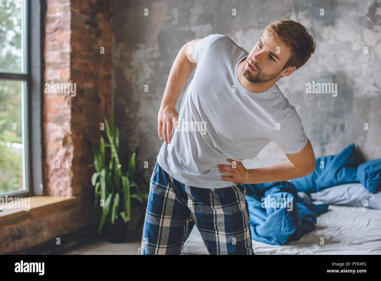 Junger Mann tun, körperliche Bewegung während der Morgen Zeit zu Hause Stockfoto
