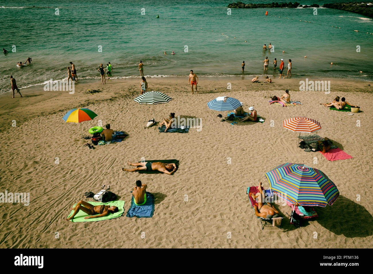 Urlauber genießen Sie ein Sonnenbad am Strand, Torviscas, Playa El Duque, Costa Adeje, Teneriffa, Kanarische Inseln, Spanien Stockfoto