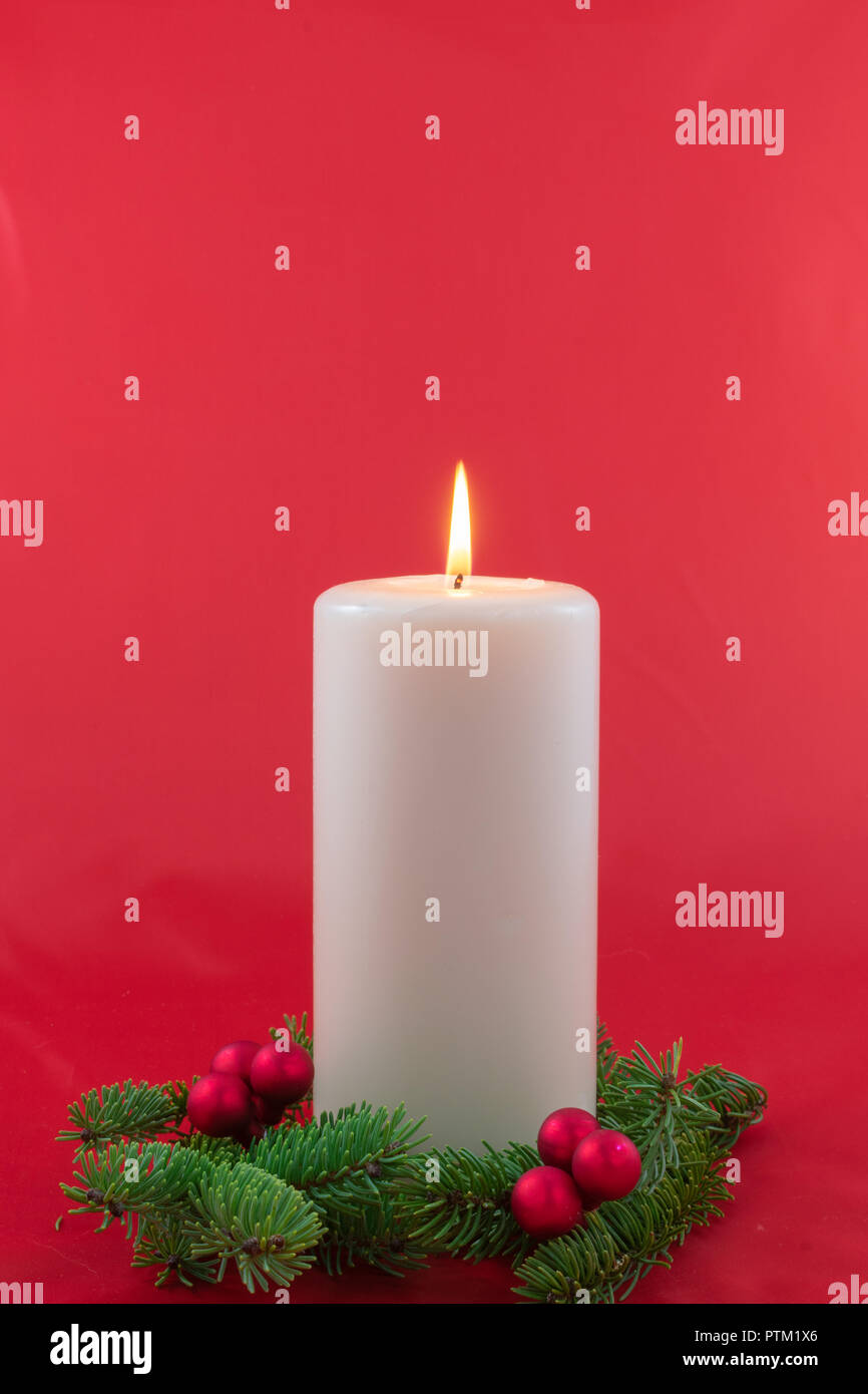Eine einzige Kerze mit Zweigen Fichte mit roten Beeren Cluster umgeben Stockfoto
