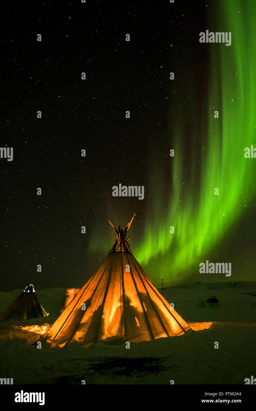 Freunde warm halten in einem traditionellen samischen Zelt unter dem Nordlicht in der Nähe von Tromsö in Nordnorwegen. Stockfoto