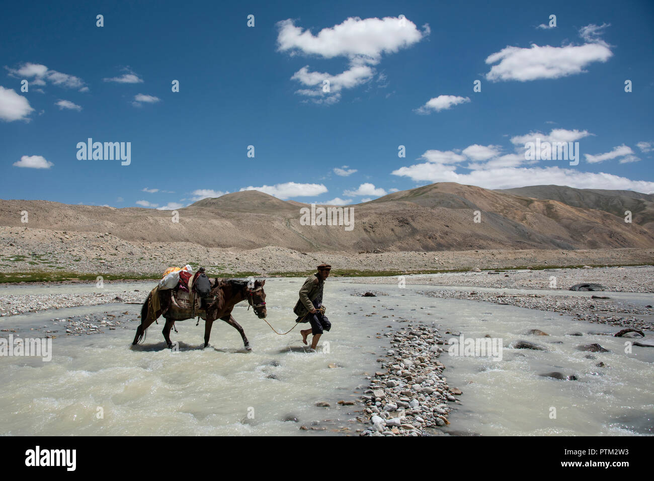 Ein Mann aus dem Wakhi Wakhan Korridor von Afghanistan, die einen Fluß überquert. Stockfoto