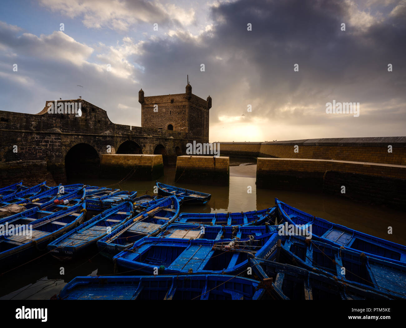 ESSAOUIRA, MAROKKO - ca. Mai 2018: Sonnenuntergang über dem Hafen von Essaouria und die berühmten Castelo Real von Mogador. Stockfoto